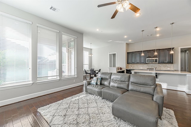 living room with baseboards, visible vents, dark wood finished floors, ceiling fan, and recessed lighting