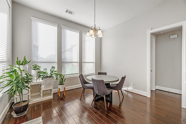 dining area with a chandelier, dark wood finished floors, visible vents, and baseboards