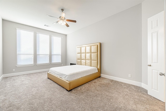 carpeted bedroom featuring baseboards, visible vents, and a ceiling fan