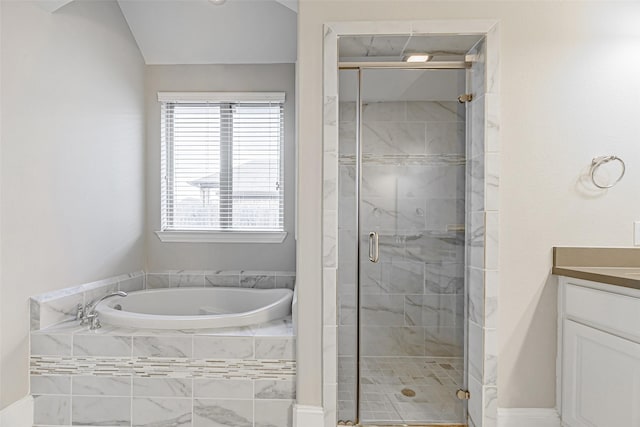 full bathroom with a stall shower, a bath, and vanity