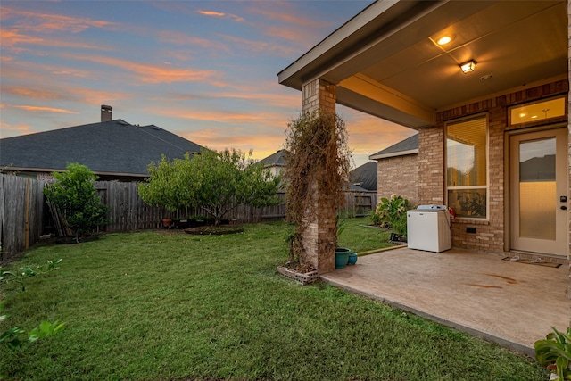 yard at dusk featuring a patio area and a fenced backyard