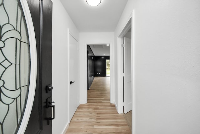 corridor with light hardwood / wood-style floors