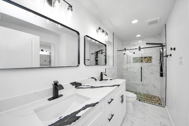 bathroom featuring vanity, a shower with door, and toilet