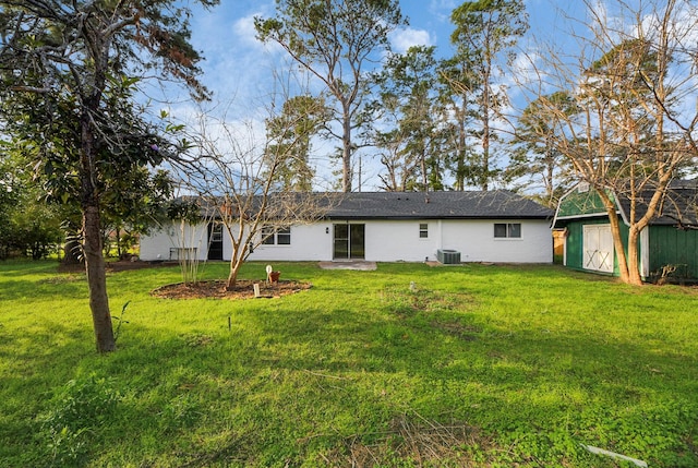 rear view of house with a shed, cooling unit, and a lawn