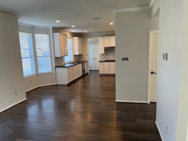 kitchen featuring ornamental molding, dark wood-type flooring, white cabinets, and decorative backsplash