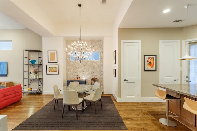 dining room with light wood-type flooring and a notable chandelier