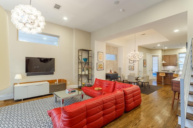 living room featuring hardwood / wood-style flooring, an inviting chandelier, and a wealth of natural light