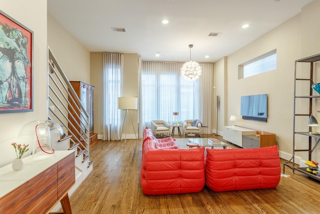 living room with a notable chandelier and light hardwood / wood-style floors