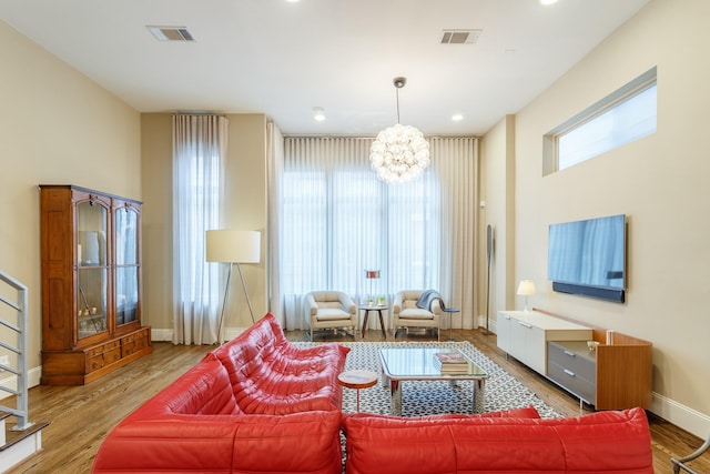 living room with light hardwood / wood-style floors and an inviting chandelier