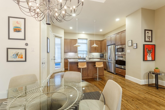 kitchen featuring hardwood / wood-style flooring, tasteful backsplash, stainless steel appliances, and wall chimney range hood