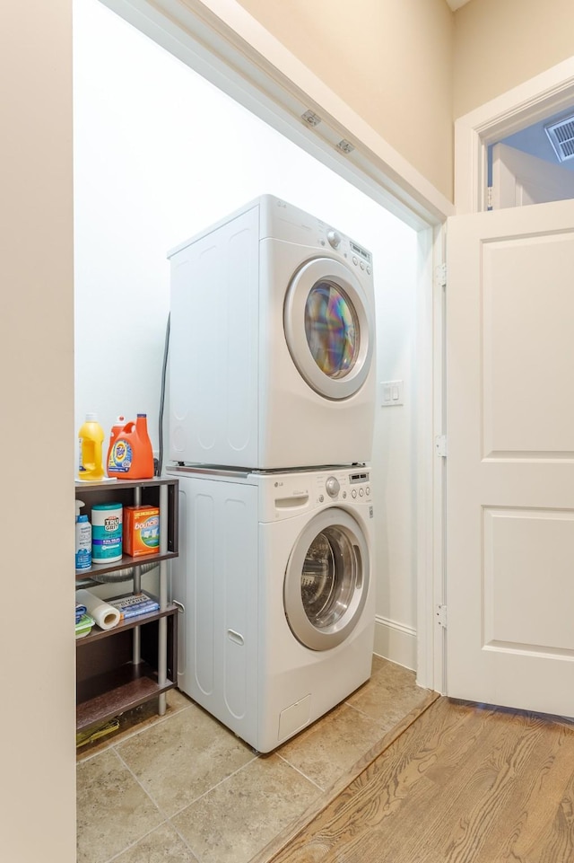 clothes washing area featuring stacked washer and clothes dryer