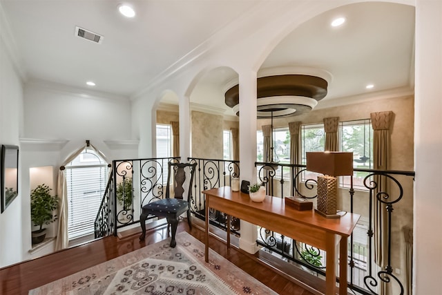 corridor with ornamental molding, recessed lighting, visible vents, and wood finished floors