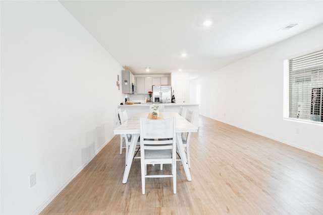 dining room with baseboards, light wood-type flooring, visible vents, and recessed lighting