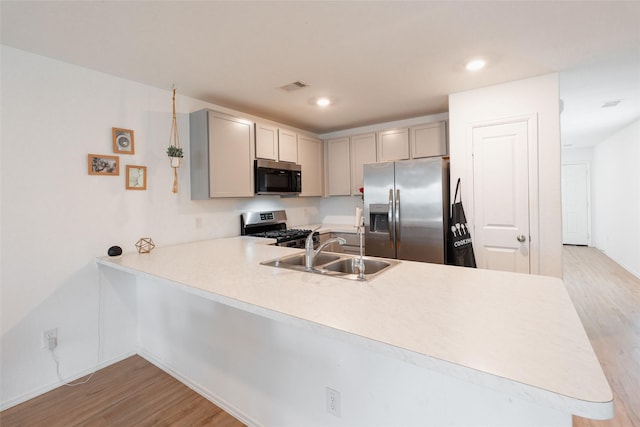 kitchen with stainless steel appliances, light countertops, a sink, and visible vents