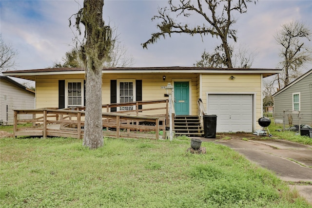 single story home featuring covered porch, a front lawn, and a garage