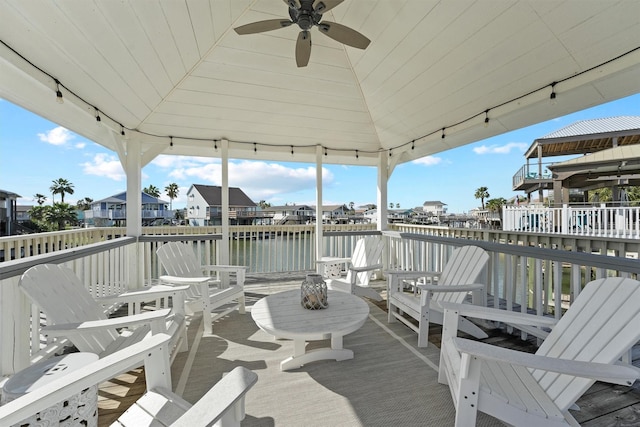 exterior space with ceiling fan, a deck with water view, and a gazebo