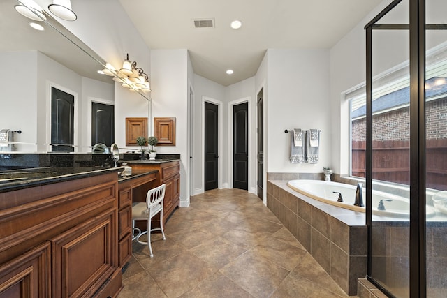 bathroom with tiled bath and vanity