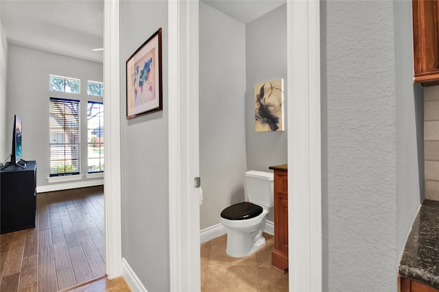 bathroom featuring toilet, vanity, and hardwood / wood-style floors