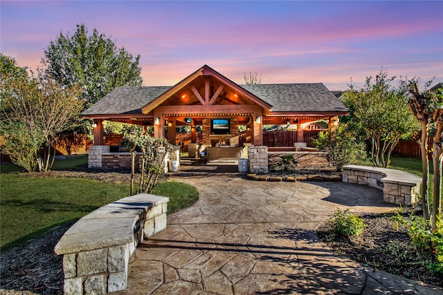 view of front of property with a fireplace, a patio, a gazebo, and a lawn