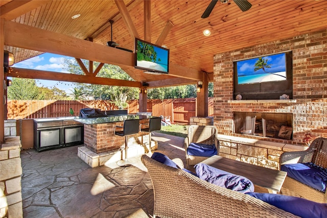 view of patio featuring grilling area, ceiling fan, a gazebo, area for grilling, and an outdoor living space with a fireplace