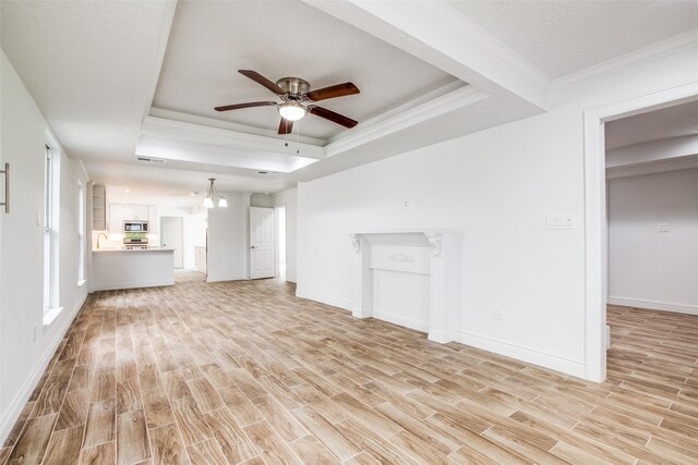 unfurnished living room featuring a raised ceiling, light wood-type flooring, crown molding, and ceiling fan