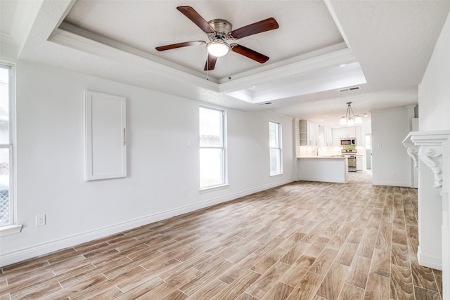 unfurnished living room featuring ornamental molding, ceiling fan, light hardwood / wood-style floors, and a raised ceiling