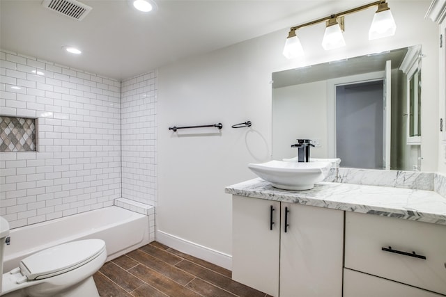full bathroom with toilet, vanity, and tiled shower / bath combo