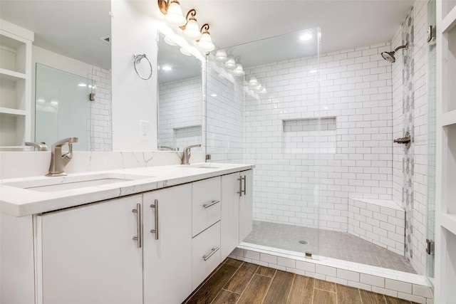 bathroom with a tile shower and vanity
