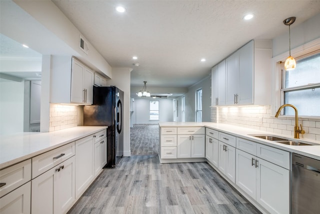kitchen with sink, black refrigerator with ice dispenser, white cabinetry, decorative light fixtures, and stainless steel dishwasher