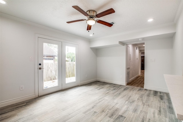 empty room with a textured ceiling, ornamental molding, ceiling fan, and light hardwood / wood-style floors