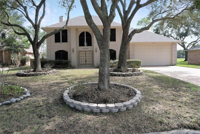 view of front of home with concrete driveway, brick siding, a chimney, and an attached garage