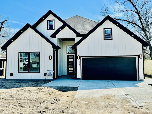 modern farmhouse style home featuring concrete driveway, roof with shingles, and board and batten siding