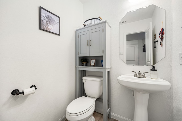 bathroom featuring hardwood / wood-style flooring and toilet