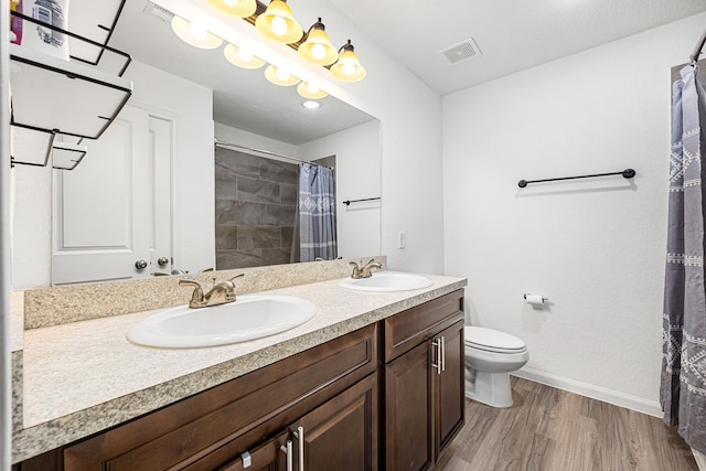 bathroom with toilet, hardwood / wood-style flooring, a shower with curtain, and vanity