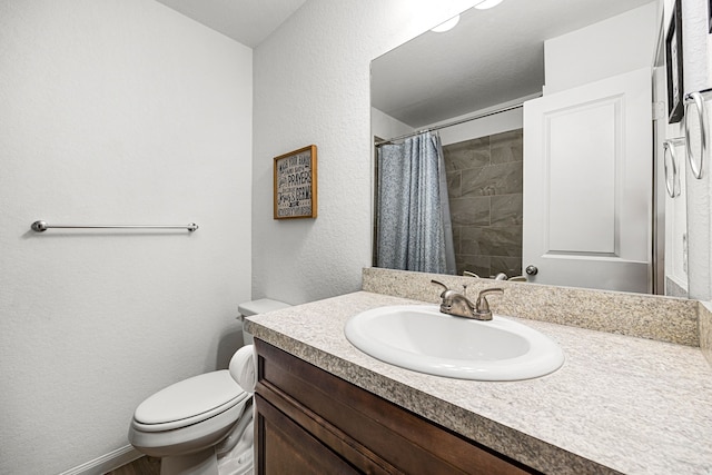 bathroom featuring toilet, vanity, and curtained shower