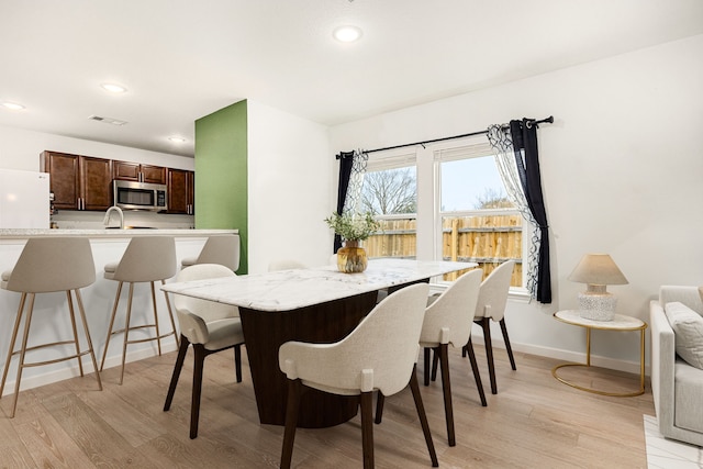 dining area featuring sink and light hardwood / wood-style floors