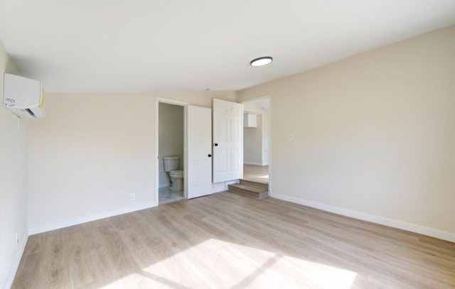 empty room featuring light hardwood / wood-style flooring and a wall unit AC