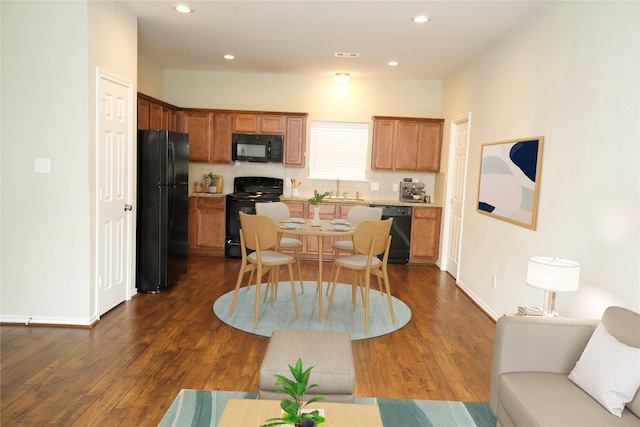 kitchen with sink, dark hardwood / wood-style floors, and black appliances