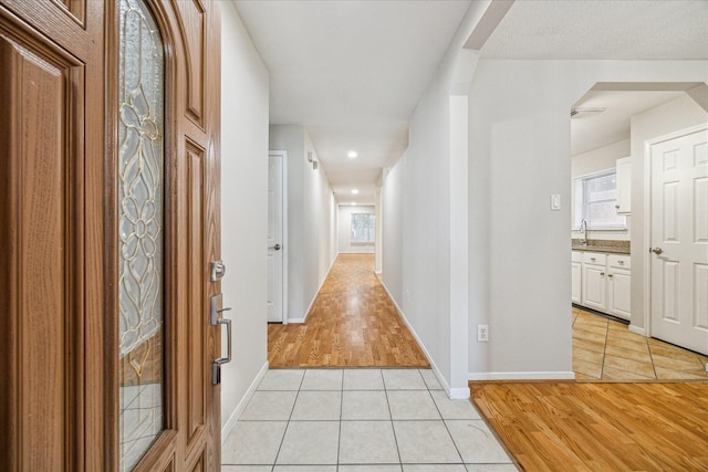 hall with light tile patterned floors and sink