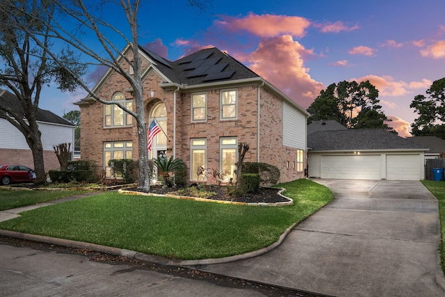 view of front of house with a yard, solar panels, and a garage