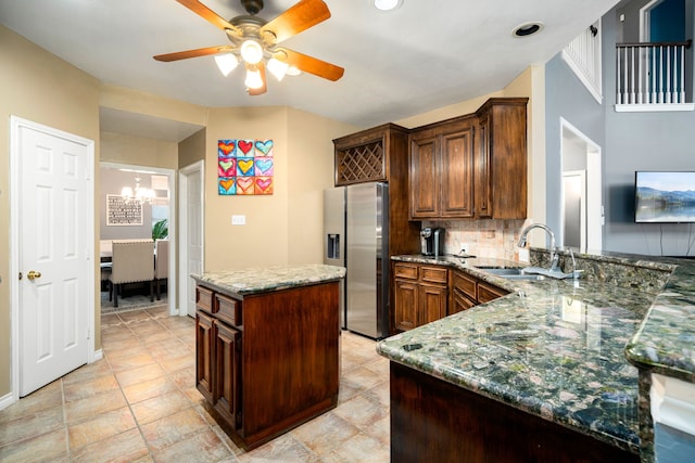 kitchen with kitchen peninsula, stainless steel fridge with ice dispenser, a center island, sink, and tasteful backsplash