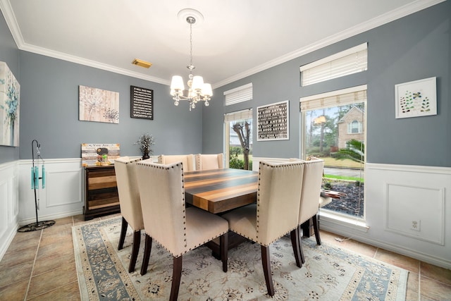 dining room with ornamental molding and a chandelier