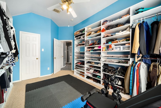 spacious closet with vaulted ceiling, ceiling fan, and light colored carpet