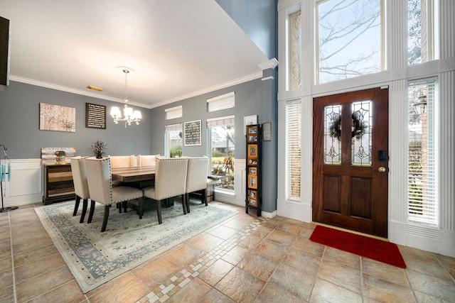 foyer entrance featuring an inviting chandelier and crown molding