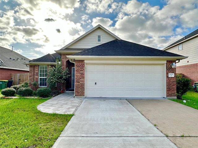 single story home featuring brick siding, a garage, concrete driveway, and a front yard