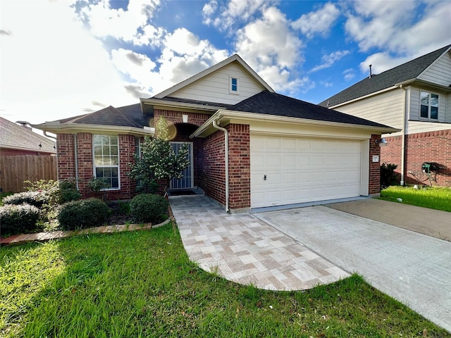 traditional-style home with brick siding, a front lawn, fence, concrete driveway, and an attached garage