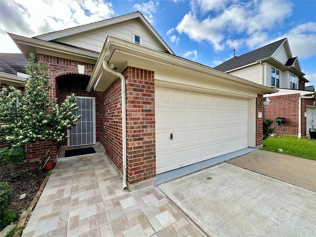 exterior space with a garage, brick siding, and concrete driveway