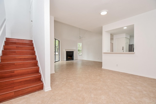 unfurnished living room featuring light tile patterned floors and ceiling fan