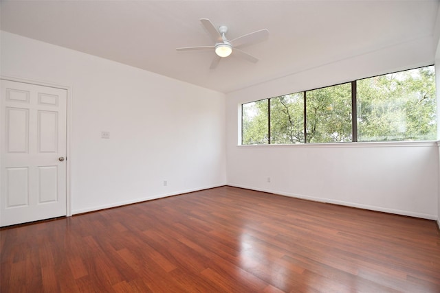 unfurnished room featuring dark wood-type flooring and ceiling fan