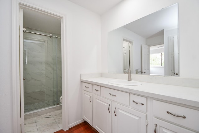 bathroom featuring vanity, an enclosed shower, and toilet